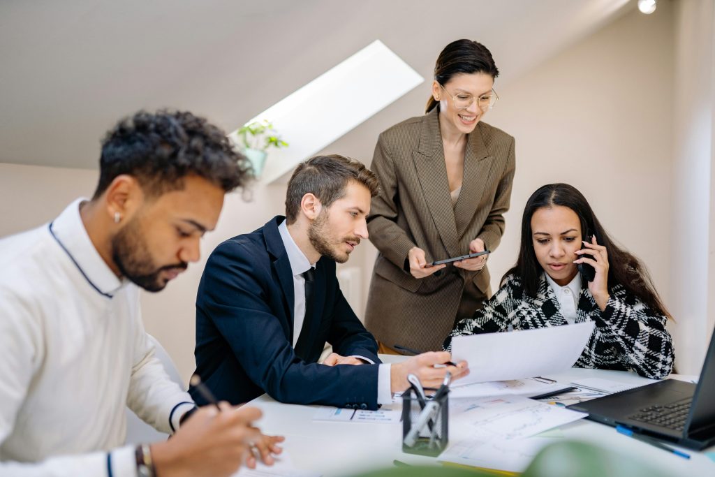 Group of professionals collaborating in a bright, modern office environment with digital devices.